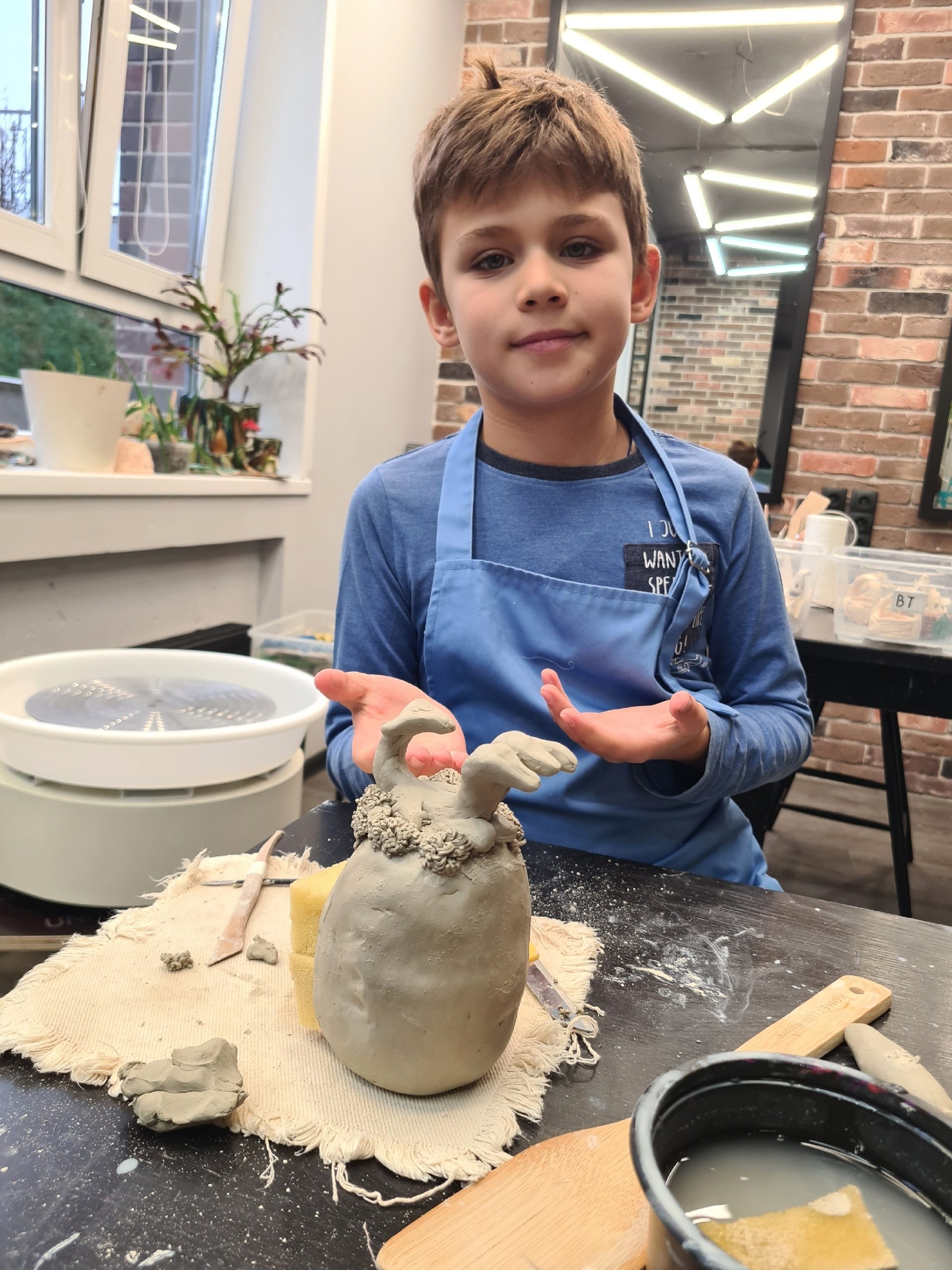 Мальчик лепит из глины